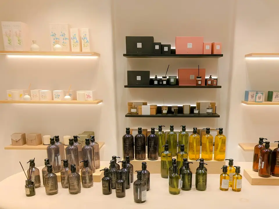 Mesa y estantes de una tienda de belleza con frascos y envases